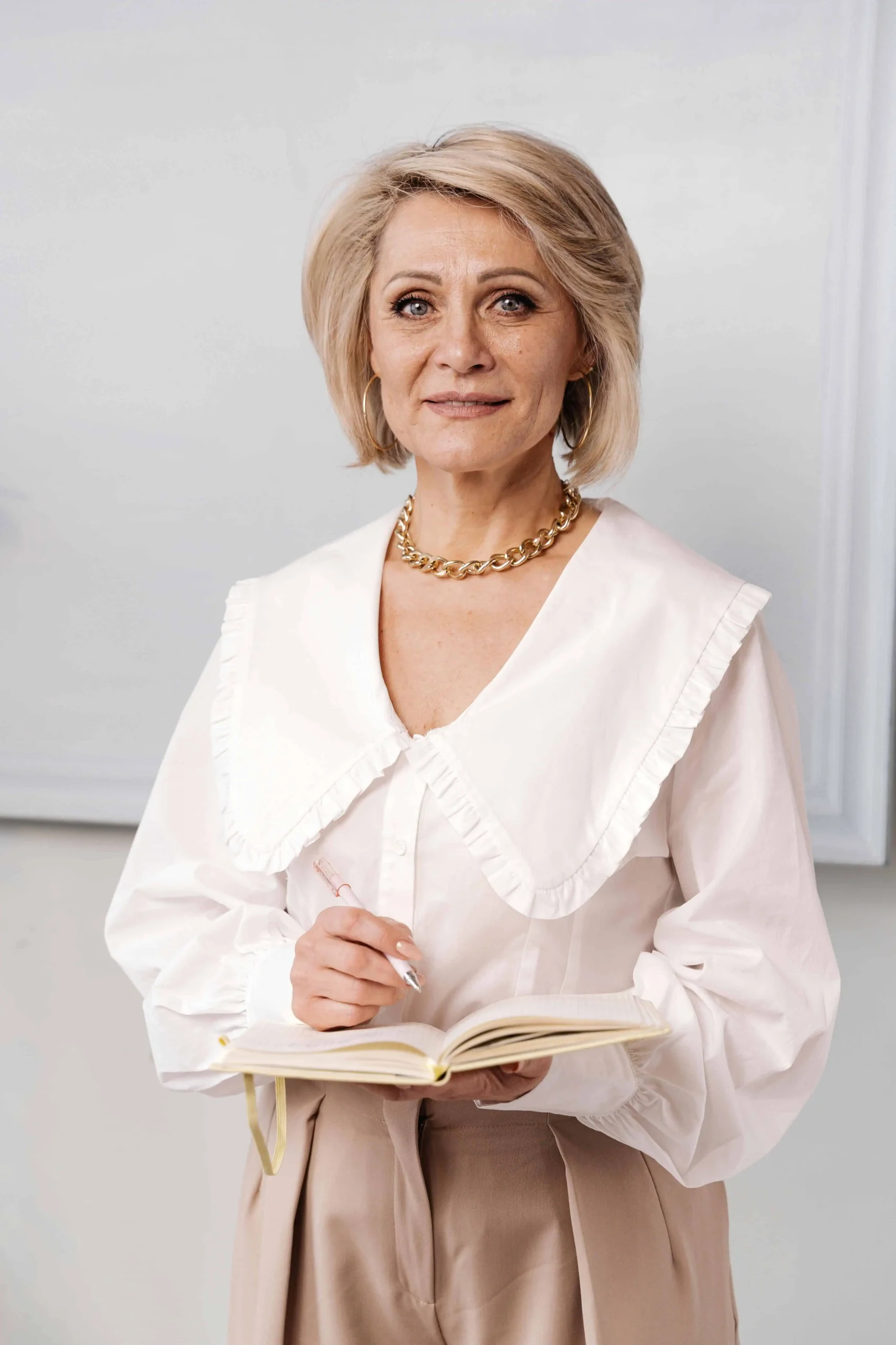 Kabbalista Avigail segurando um caderno de anotações, usando vestes claras elegantes, representante espiritual do mês hebraico de Tamuz.