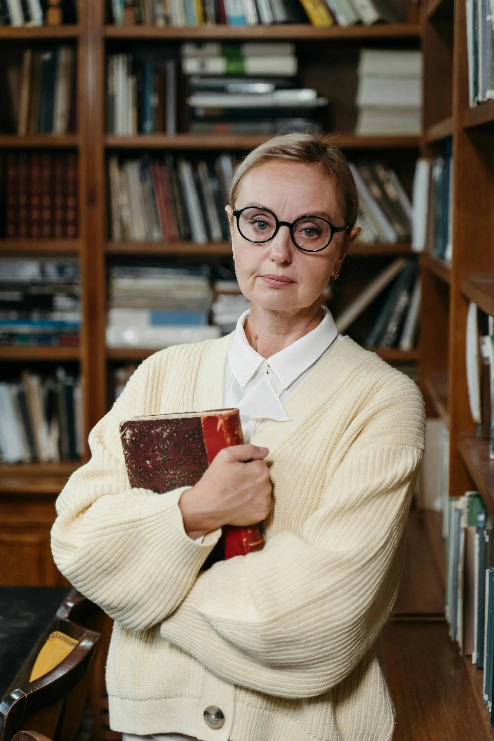 Kabbalista Michal segurando um livro antigo em biblioteca, representante espiritual do mês hebraico de Kislev.